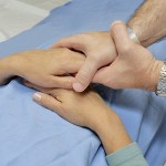 A doc comforts a patient on an examining table before a procedure.